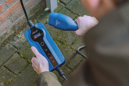 Hands holding the blue Voldt mobile Type 2 EV charging cable with control unit