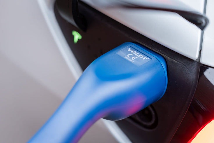 Close-up of a blue Voldt Type 2 EV charging cable connector in a white car's charging port