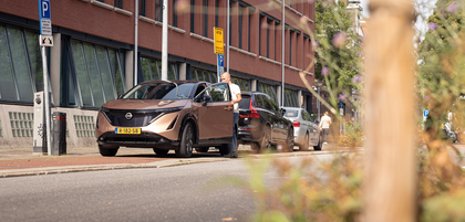 Bronze Nissan Ariya parked at a public charging station, compatible with Voldt EV charging cables