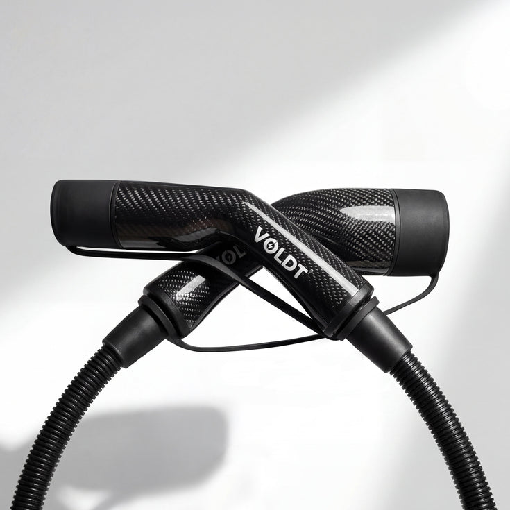 Studio shot of the black carbon fibre Voldt Type 2 EV charging cable and its connectors