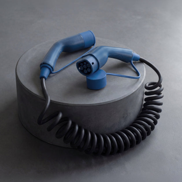 Voldt® coiled EV charging cable displayed on a grey concrete plinth
